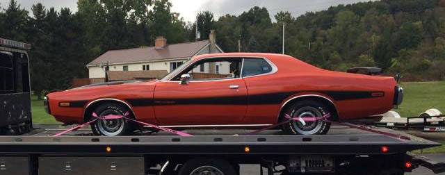 Classic sports car on flatbed tow truck
