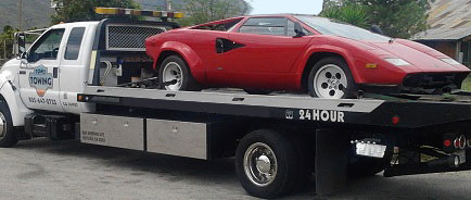flatbed tow truck towing sports cars